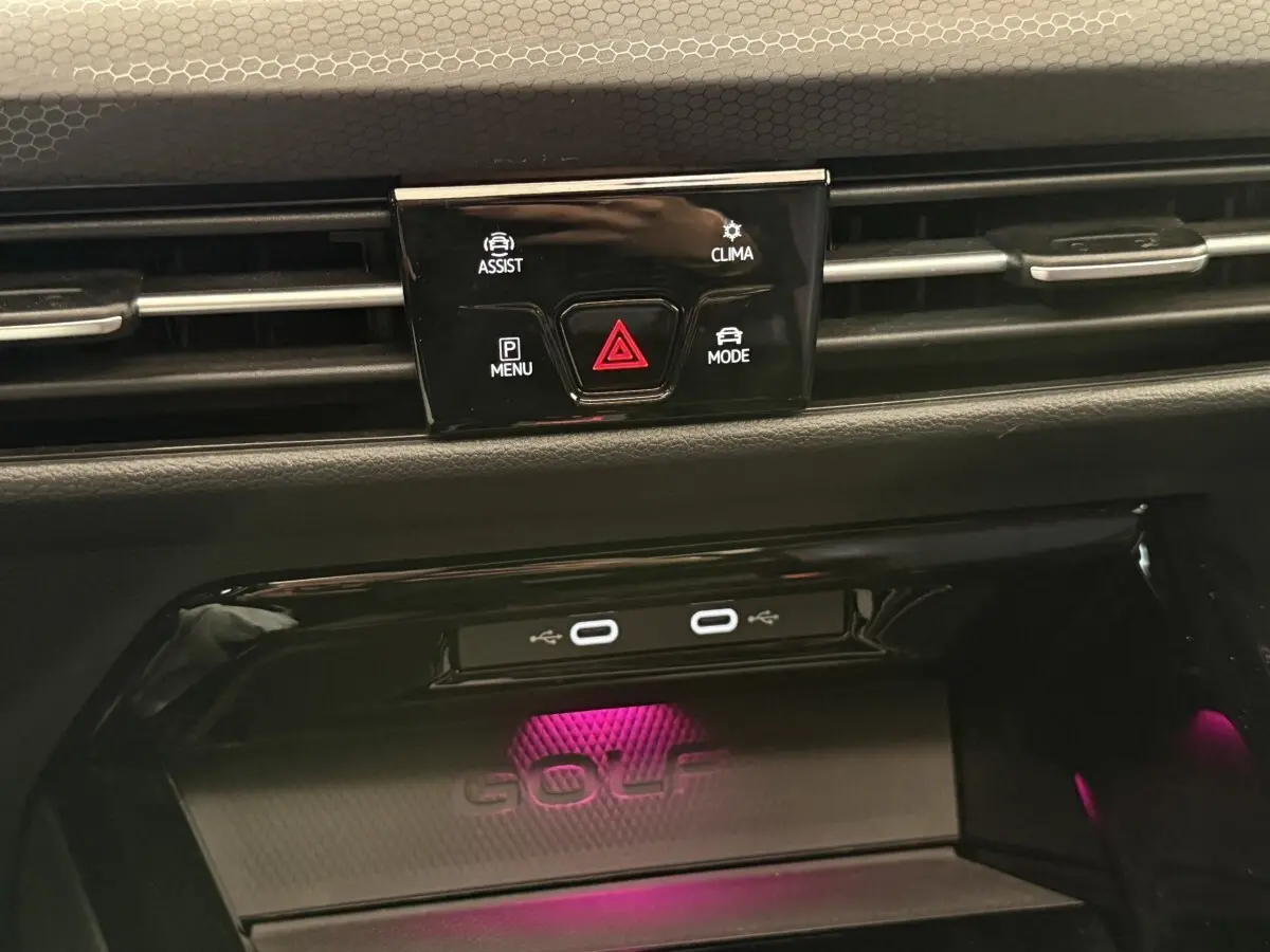 Détail du tableau de bord noir de la Volkswagen Golf GTI Clubsport 2022 avec éclairage d’ambiance violet et ports USB-C.