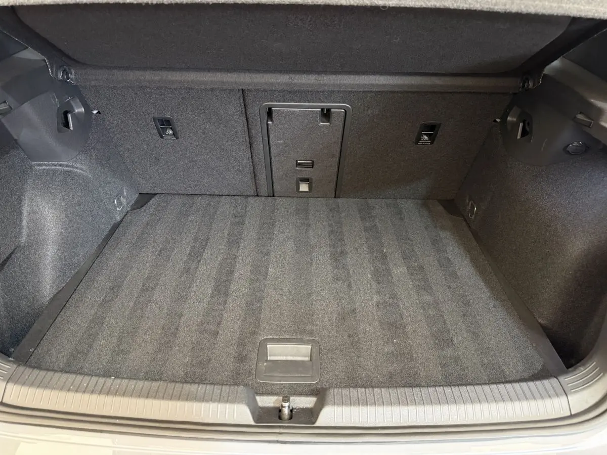 Coffre spacieux et propre de Volkswagen Golf GTI Clubsport 2022, vue intérieure depuis l'ouverture arrière, moquette grise.