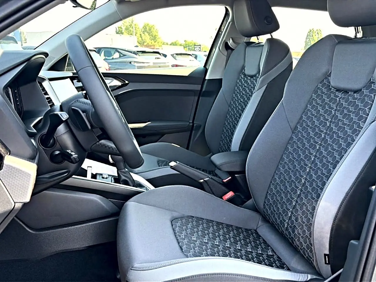 Vue intérieure côté gauche montrant les sièges sport gris et noir avec motifs hexagonaux de l'Audi A1 Sportback 2026.