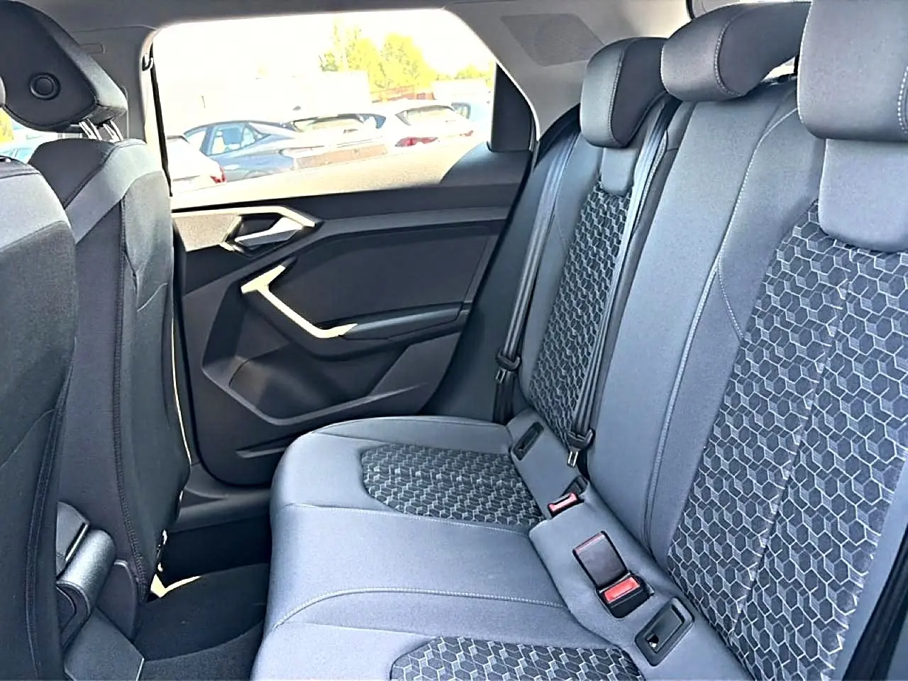 Vue intérieure arrière côté droit de l'Audi A1 Sportback 2026 avec sièges tissu gris à motifs hexagonaux.