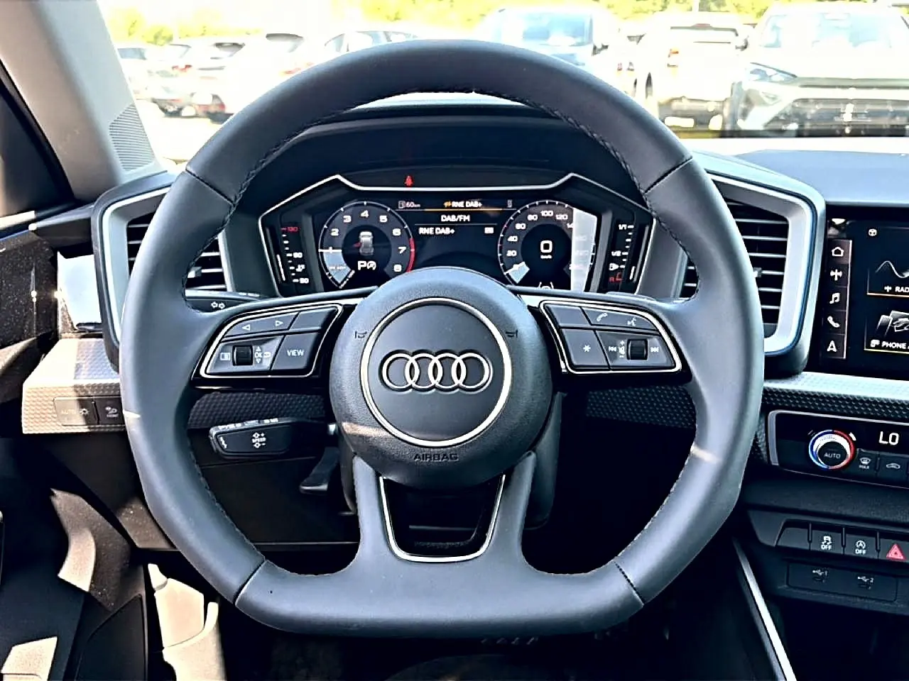 Vue rapprochée du volant cuir multifonction noir de l’Audi A1 Sportback 30 TFSI avec tableau de bord digital.