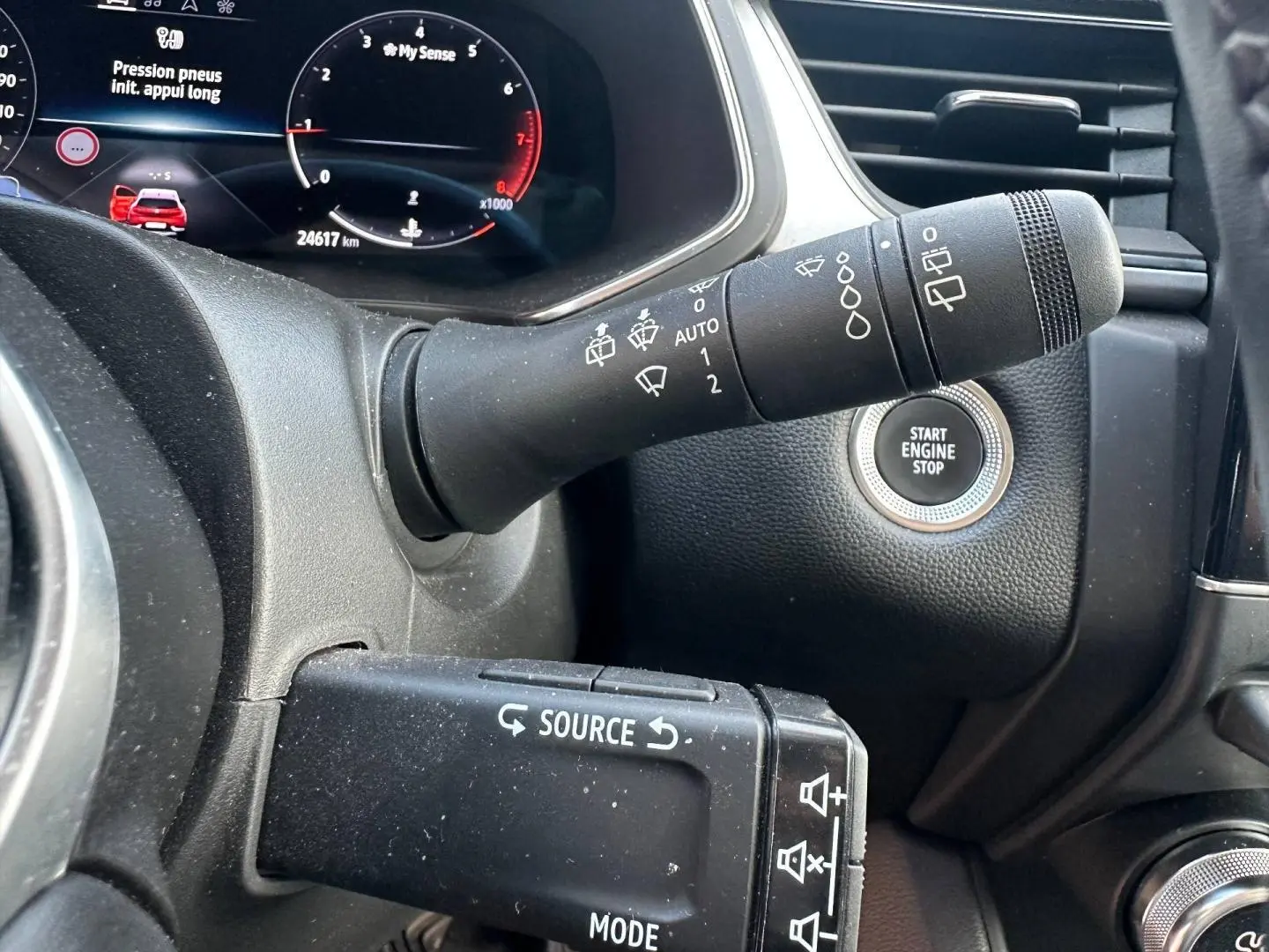 Gros plan intérieur sur la commande de phares et le bouton Start Engine Stop du Renault Captur rouge nacré 2024.