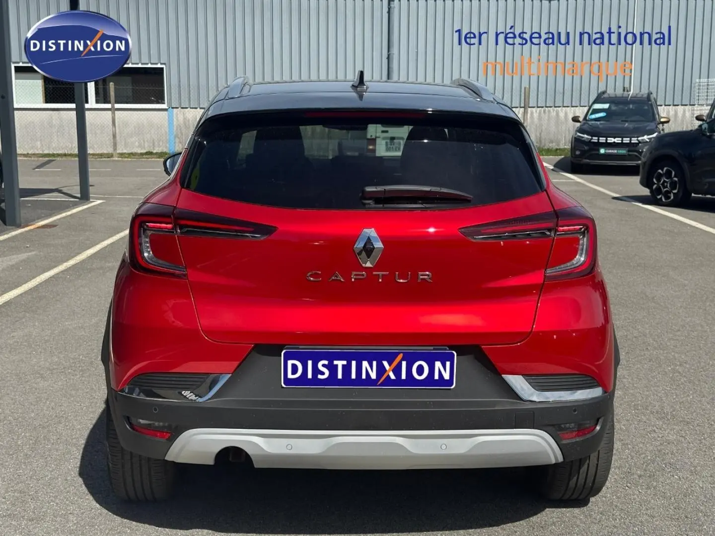 Vue arrière d’un Renault Captur 2024 rouge flamme nacré avec toit noir et feux arrière LED distinctifs.