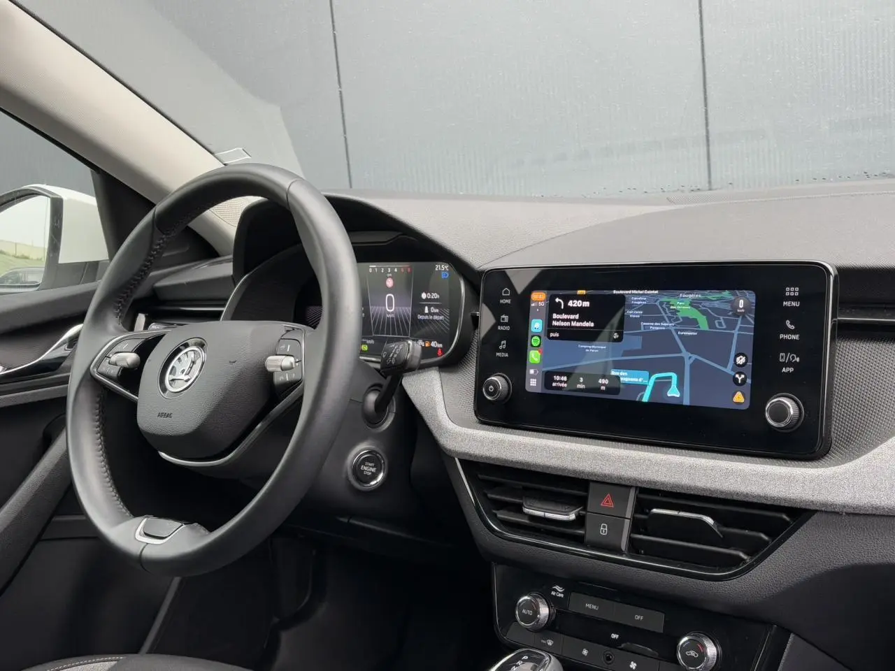 Vue intérieure côté conducteur du tableau de bord et volant cuir multifonctions d'une Skoda Scala blanc Candy 2024.