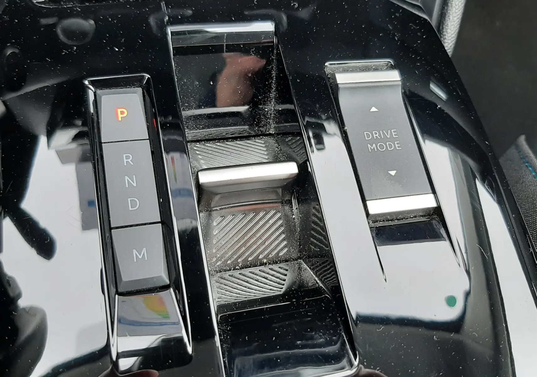 Gros plan sur la console centrale noire brillante de la Citroën C4 Hybrid 136, avec commandes de boîte auto et mode de conduite.