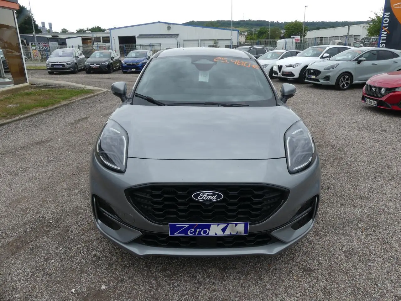 Vue frontale d'une Ford Puma gris métallisé avec calandre noire et phares LED, stationnée en extérieur.