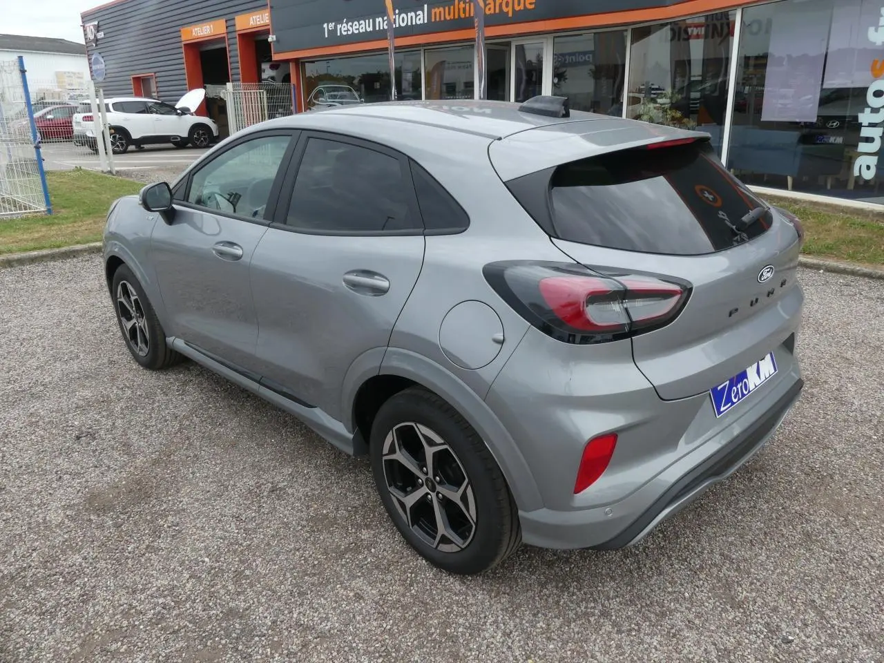 Vue 3/4 arrière droite d'un Ford Puma gris métallisé 2025 avec jantes alliage et vitres arrière surteintées.