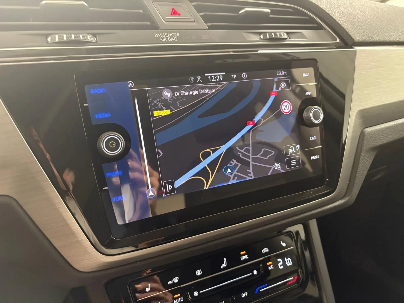 Écran tactile central du Volkswagen Touran 2025 affichant la navigation, avec commandes climatisation en dessous.