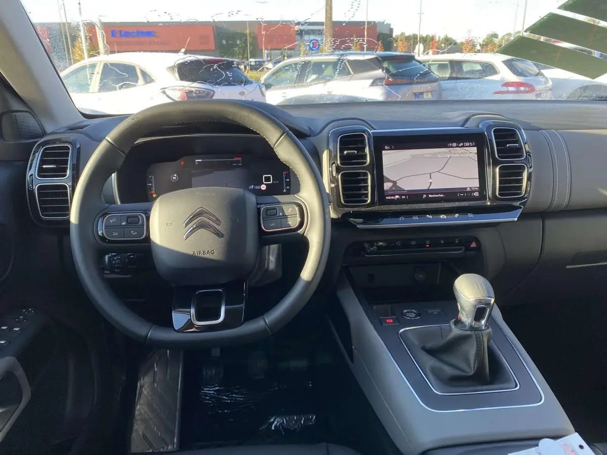 Vue intérieure du tableau de bord du Citroën C5 Aircross 2021 avec volant cuir, écran tactile et levier de vitesses manuel.