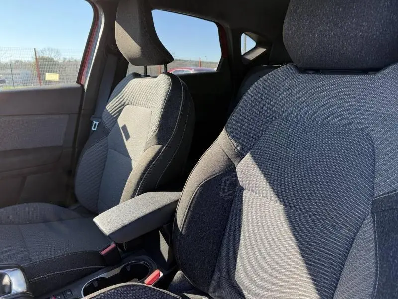 Gros plan sur les sièges avant en tissu gris du Renault Captur 2025 Rouge Flamme, intérieur lumineux côté gauche.