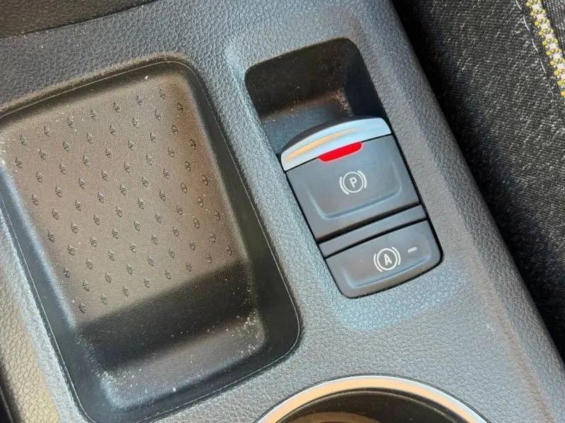 Gros plan sur les commandes de frein à main électrique et arrêt/démarrage automatique dans l'habitacle du Renault Captur 2025.