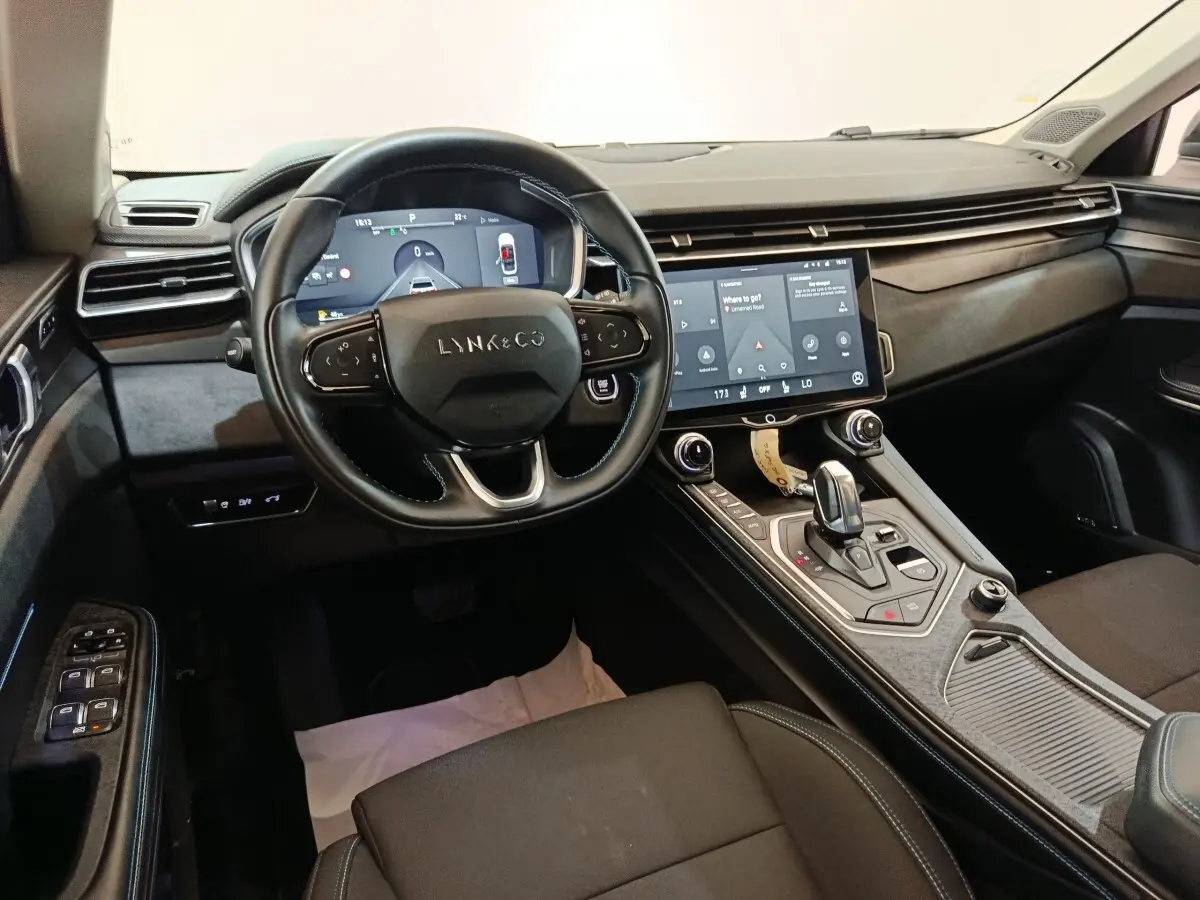 Vue intérieure côté conducteur du tableau de bord et console centrale du Lynk & Co 01 hybride rechargeable noir 2023.