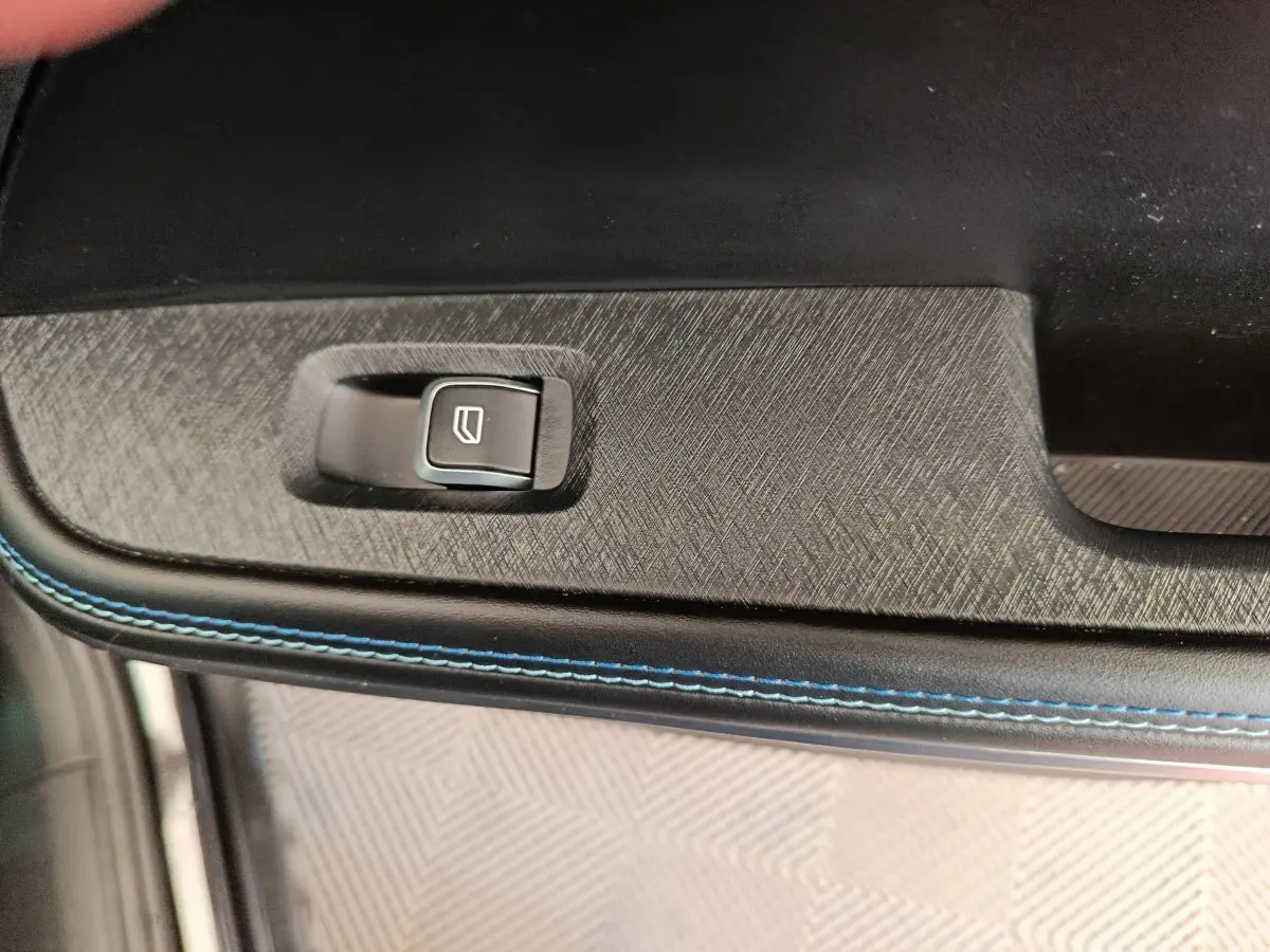 Détail de la commande de lève-vitre sur la porte intérieure avec surpiqûres bleues du LINK & CO 01 noir.