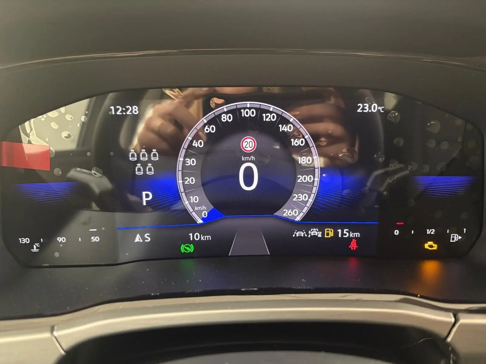 Tableau de bord numérique du Volkswagen Touran 2025 affichant la vitesse à zéro et plusieurs voyants d'alerte allumés.