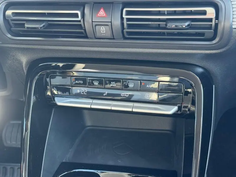 Vue rapprochée du tableau de bord noir brillant du Citroën C3 Aircross 2026, avec commandes climatisation et aérateurs.