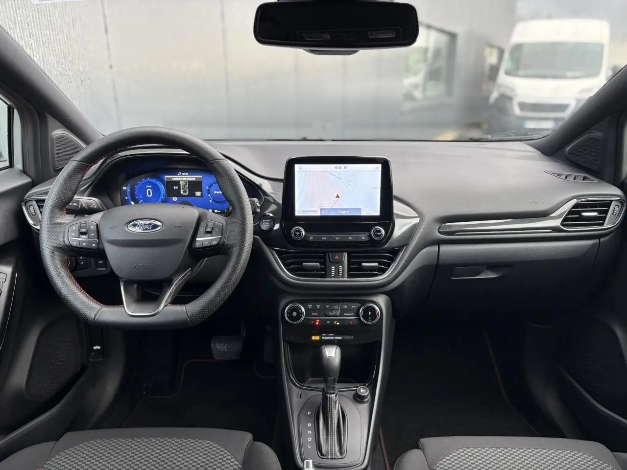 Vue intérieure avant du Ford Puma gris Solar 2023, tableau de bord avec écran tactile et volant ST-Line.