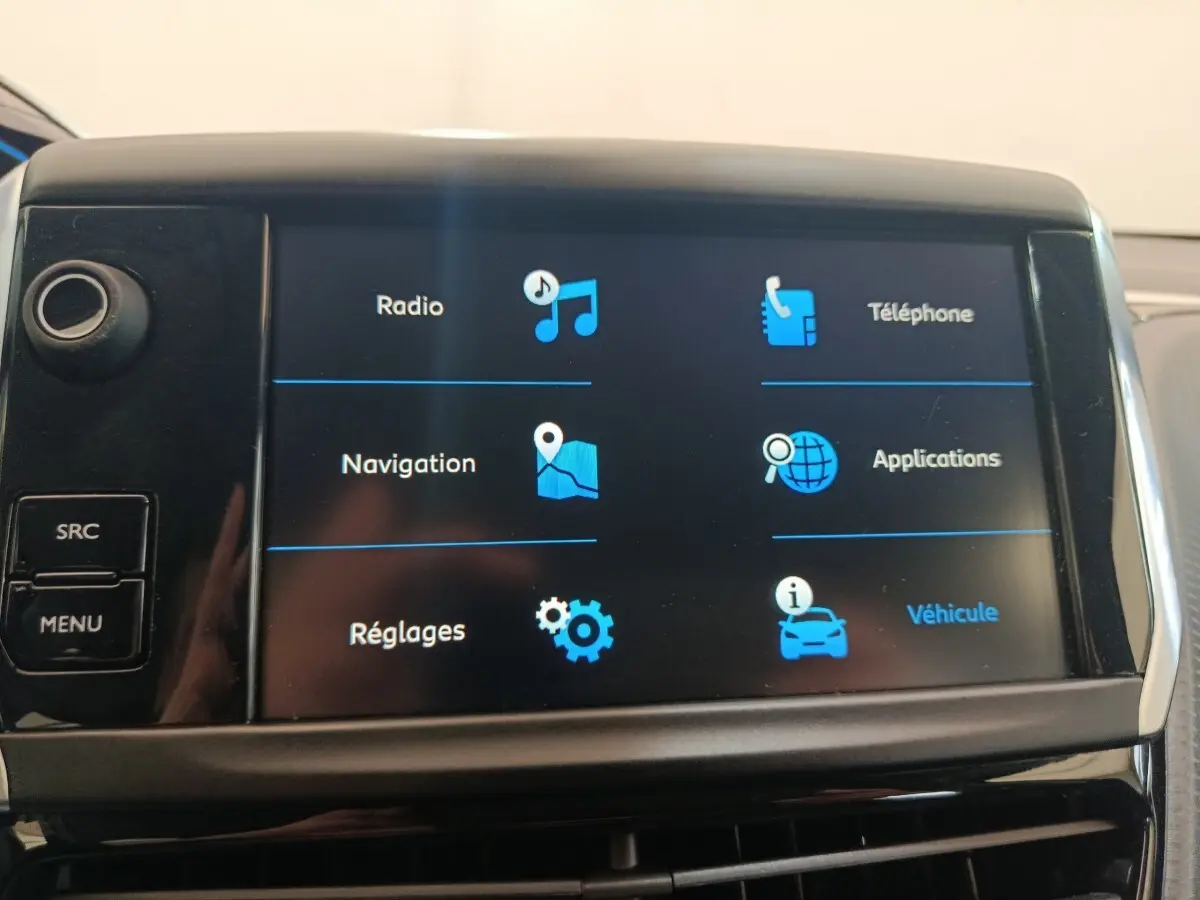 Écran tactile central du tableau de bord du Peugeot 2008 gris foncé, affichant les options radio, navigation et téléphone.