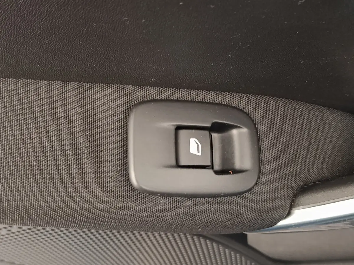 Gros plan sur le bouton d'ouverture de coffre intérieur, tissu noir, Peugeot 2008 gris foncé 2019.