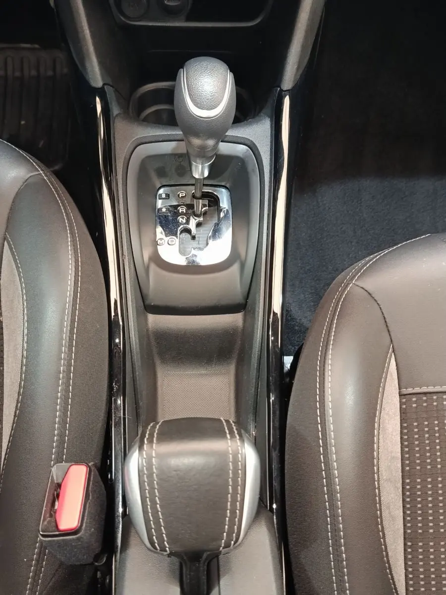Vue plongeante sur la console centrale du Peugeot 2008 gris foncé, montrant le levier de boîte automatique et les sièges avant.