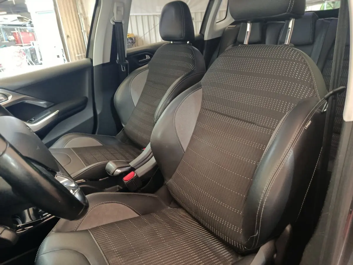 Vue intérieure rapprochée des sièges avant en tissu et cuir noir du Peugeot 2008 gris foncé, version Allure 2019.