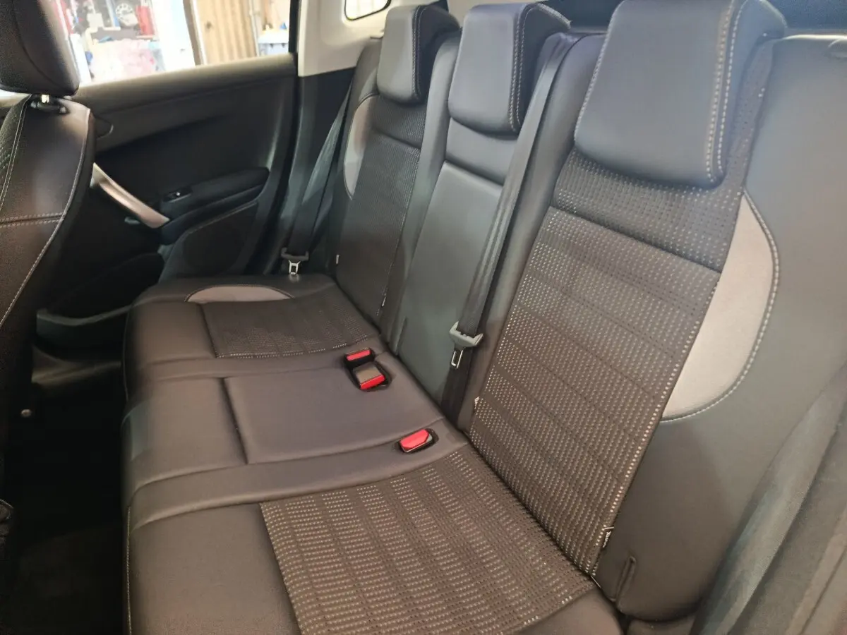 Vue intérieure côté droit sur la banquette arrière en cuir noir avec surpiqûres contrastantes du Peugeot 2008 gris foncé.