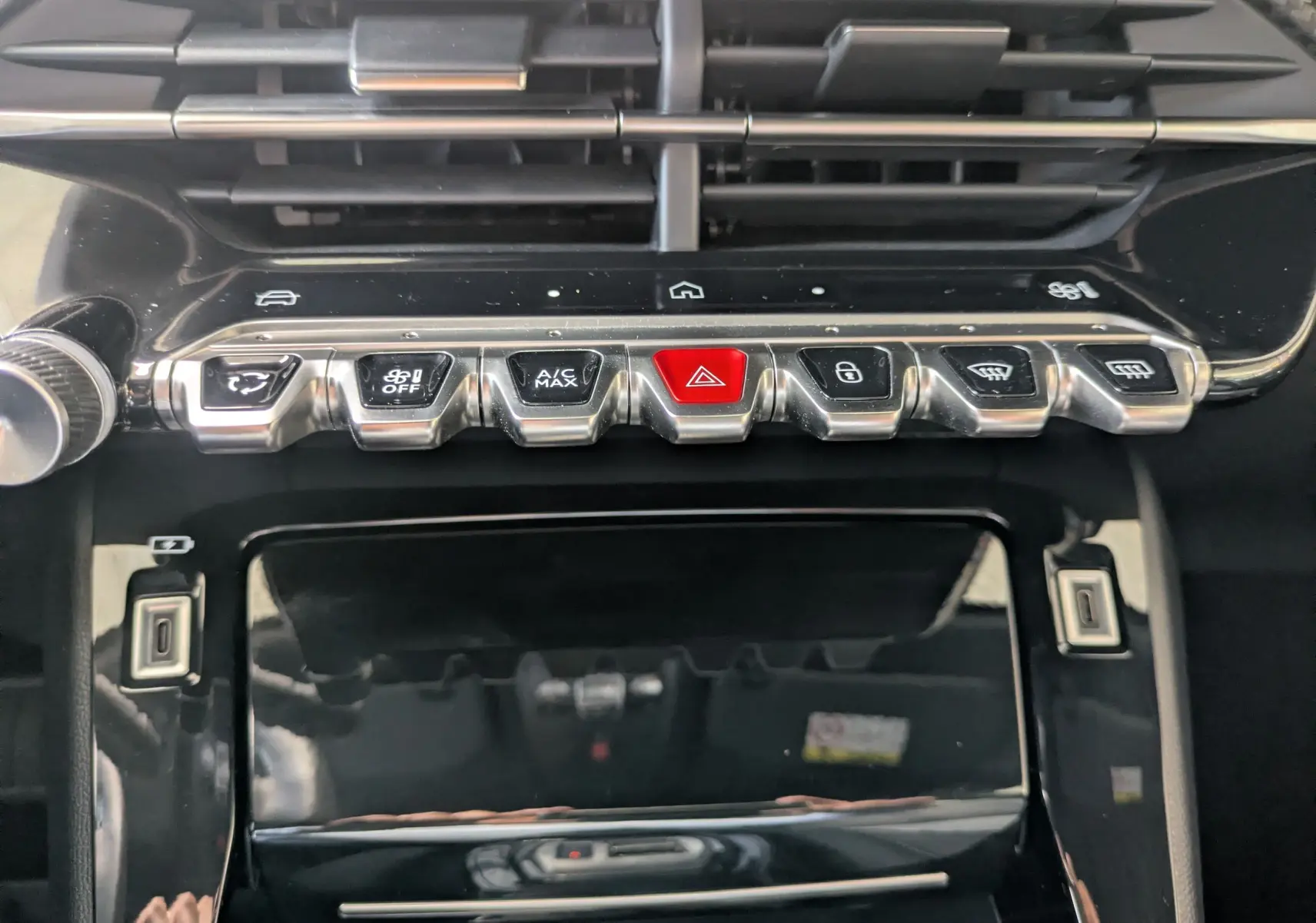 Gros plan sur la console centrale du Peugeot 2008 Hybrid 145, boutons métalliques et écran tactile noir brillant.