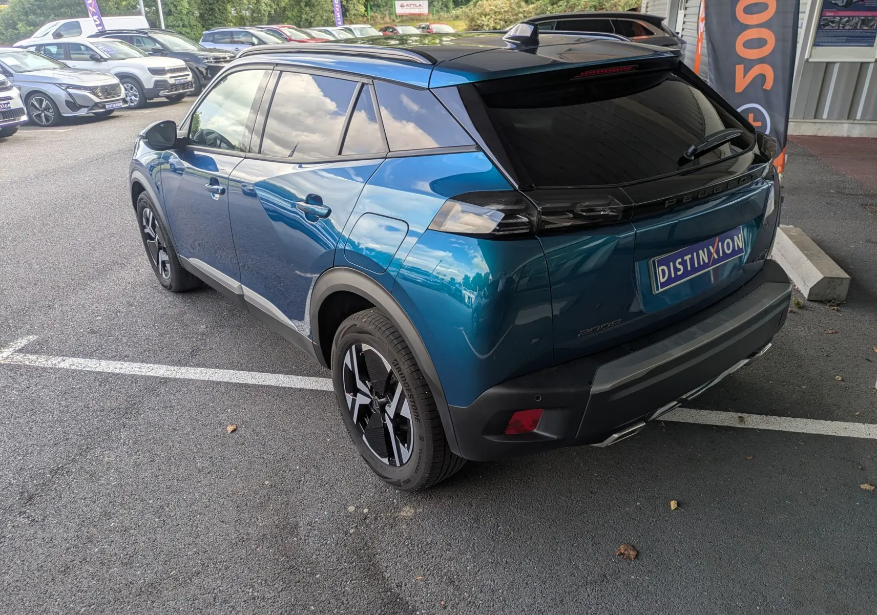 Vue 3/4 arrière droite du Peugeot 2008 Hybrid 145 bleu Obsession avec jantes alliage 17'' et toit noir brillant.