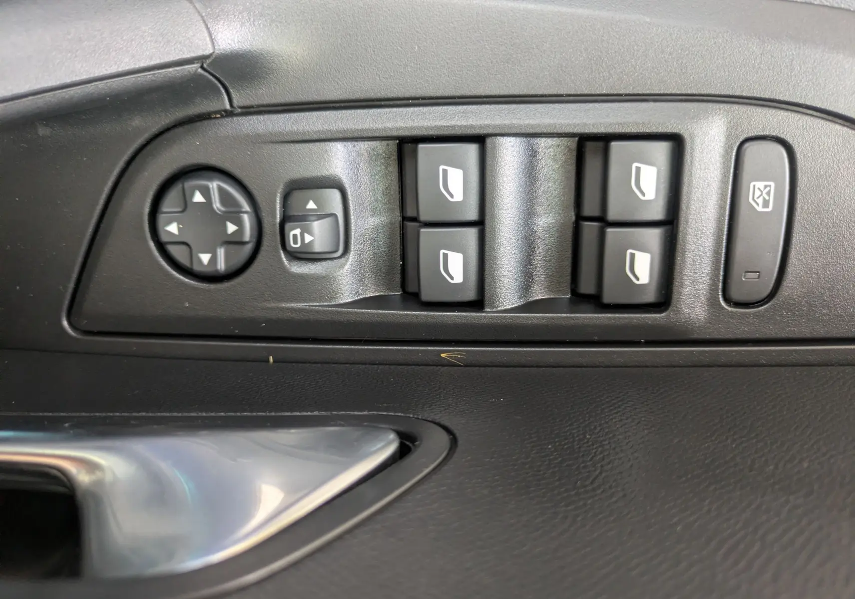Gros plan sur les commandes de lève-vitres et rétroviseurs côté conducteur du Peugeot 2008 Hybrid 145 finition Allure.