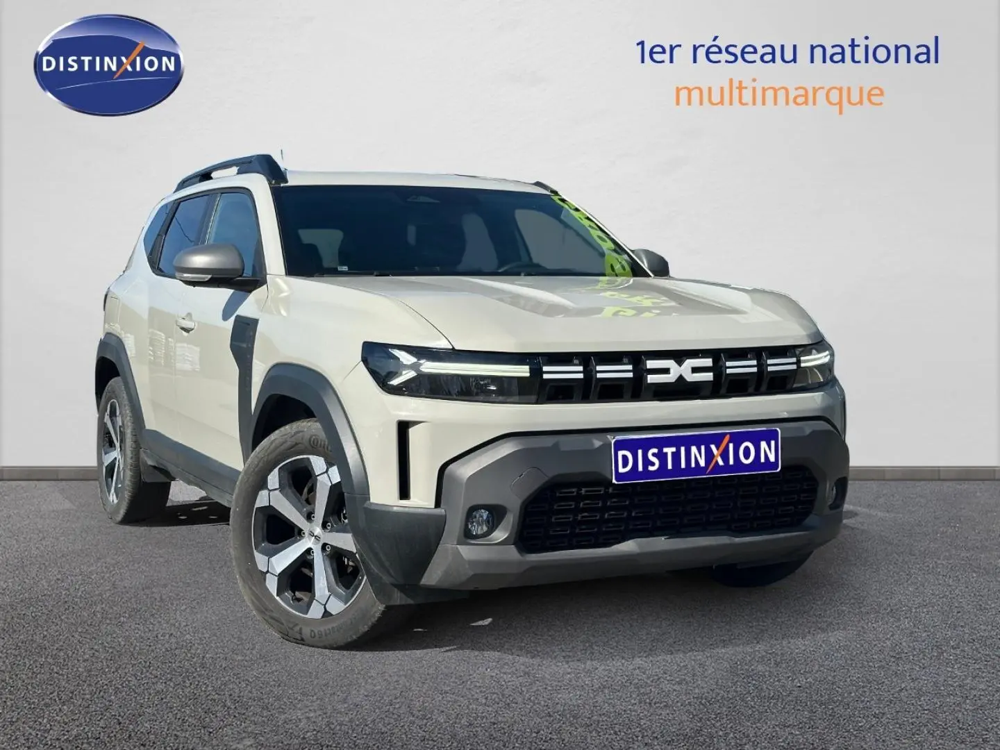 Dacia Duster 2025 couleur Sandstone vue 3/4 avant droit avec calandre noire et jantes alu bicolores.