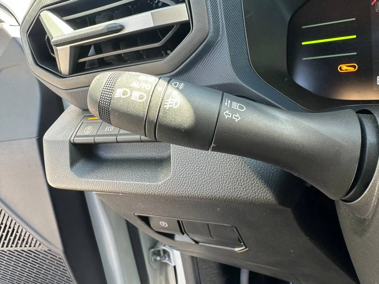 Gros plan sur la commande des feux et clignotants à gauche du tableau de bord du Dacia Duster 2025 couleur Sandstone.