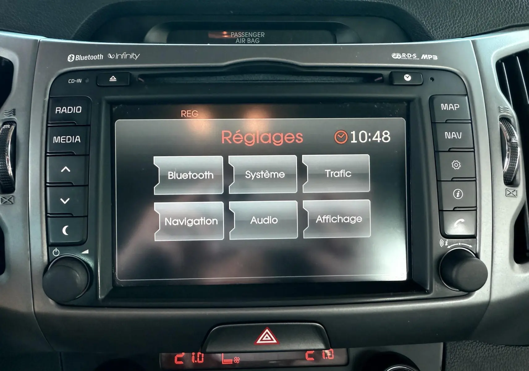 Écran tactile central de la Kia Sportage blanche 2015 affichant le menu Réglages à 10h48