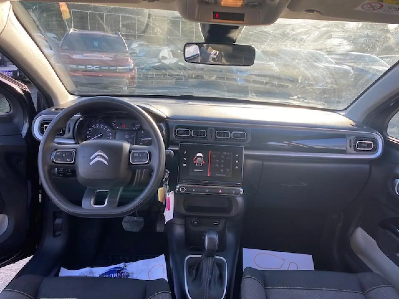 Intérieur de la Citroën C3 2023 vu de face, tableau de bord noir avec écran tactile et volant multifonction.