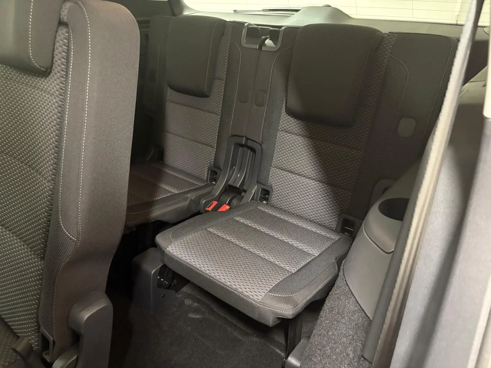 Vue intérieure sur la troisième rangée de sièges en tissu gris du Volkswagen Touran 2025, côté droit.