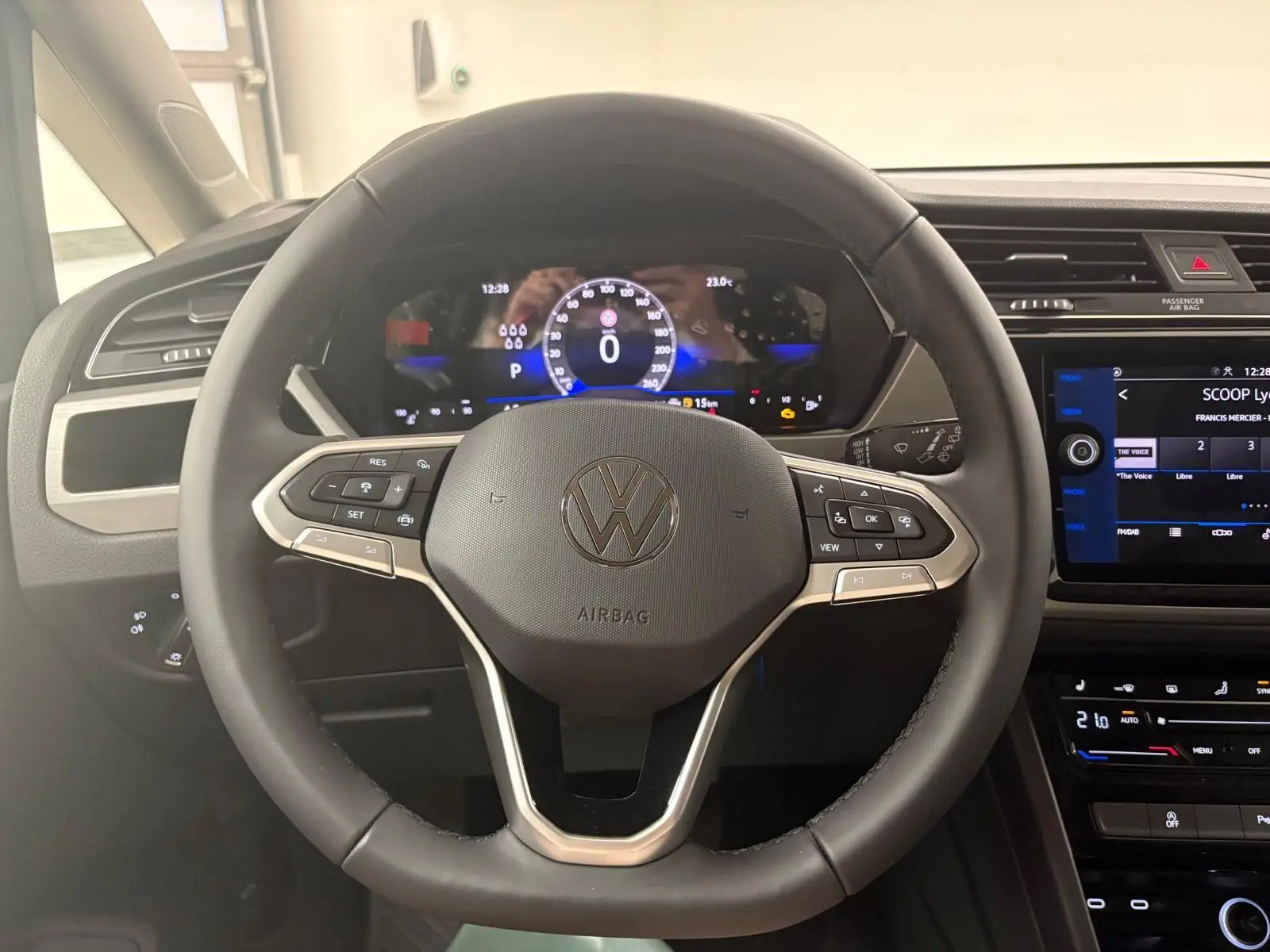 Volant noir de Volkswagen Touran 2025 avec commandes intégrées et tableau de bord numérique éclairé.