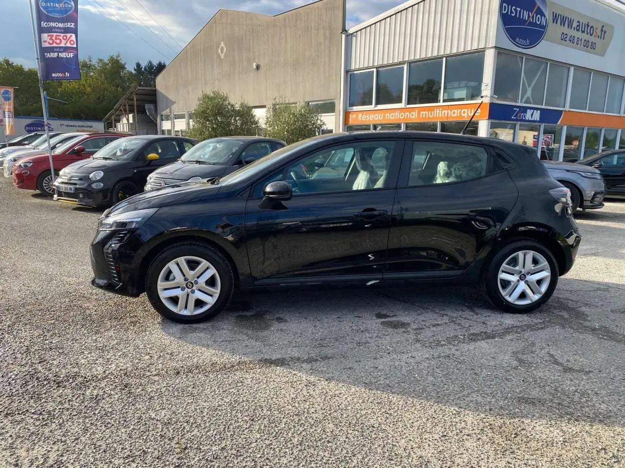 Profil côté gauche d'une Renault Clio 1.5 Blue dCi 100 Evolution noire Etoile avec enjoliveurs 16 pouces sur parking.
