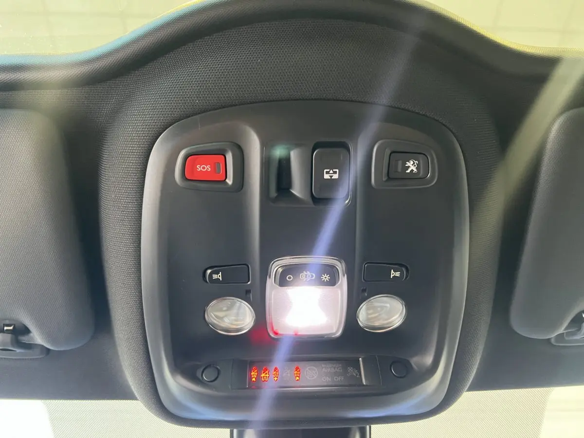 Vue en gros plan du plafonnier intérieur noir avec boutons SOS et ouverture coffre de la Peugeot 308 rouge