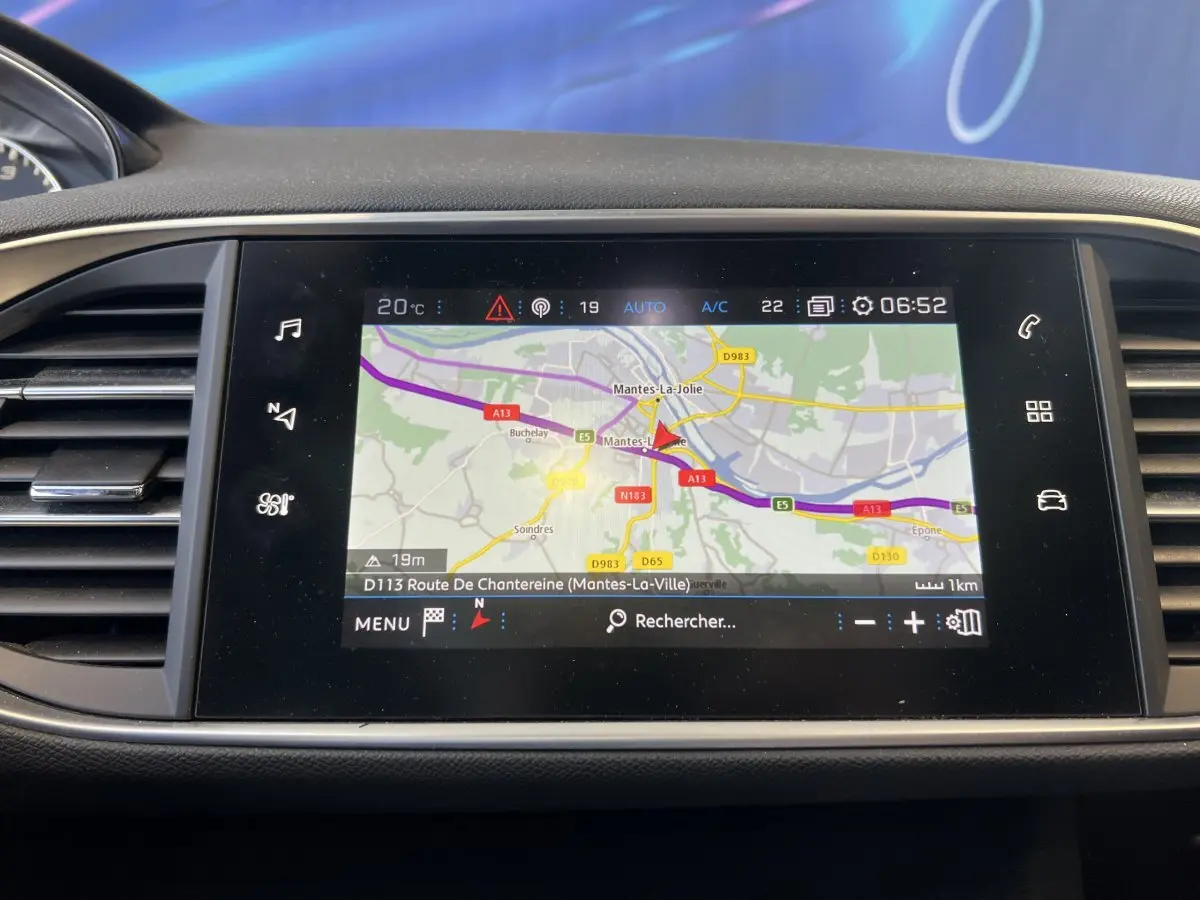 Écran tactile central affichant la navigation GPS dans l'habitacle d'une Peugeot 308 rouge, version GT Line.
