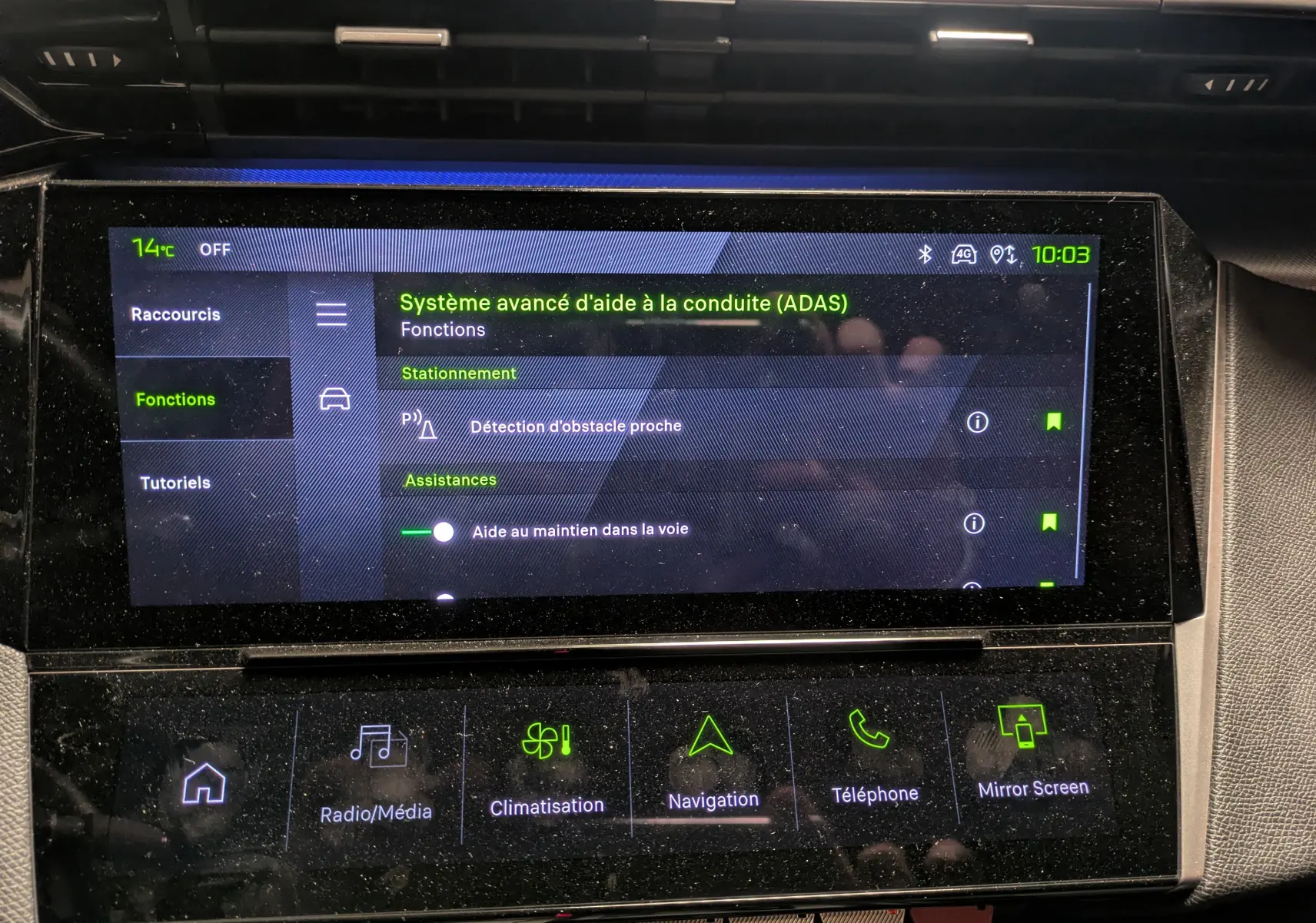 Écran tactile central du tableau de bord de la Peugeot 308 SW Hybrid gris, affichant les aides à la conduite avancées.