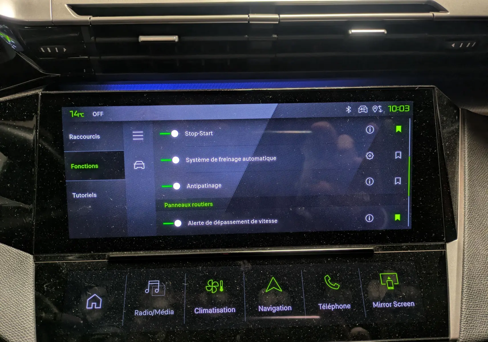 Vue rapprochée de l’écran tactile central du Peugeot 308 SW Hybrid 145 eDCS6 GT gris, affichant les fonctions d’aide à la conduite.
