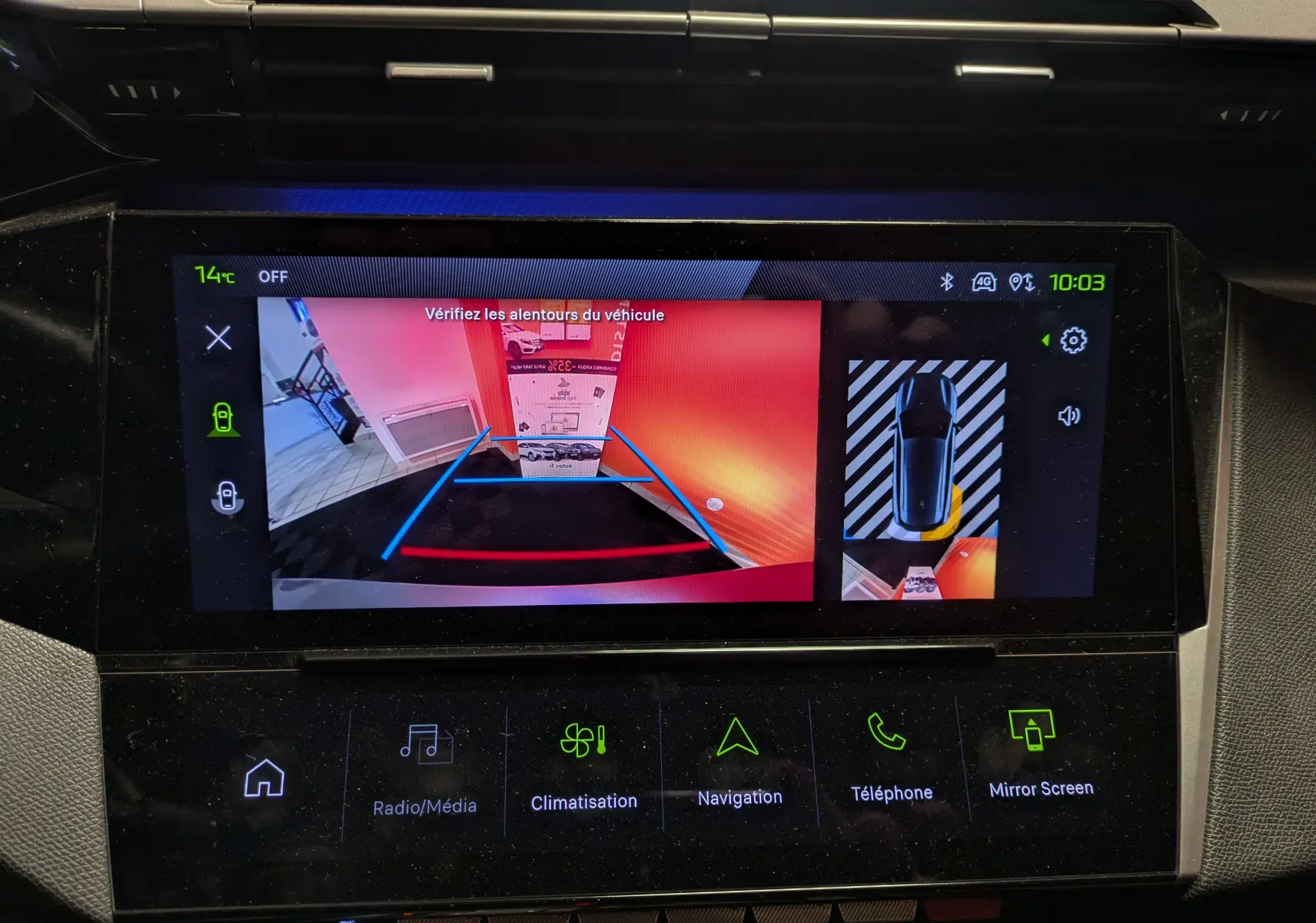 Écran intérieur de la Peugeot 308 SW Hybrid gris montrant la caméra de recul et l’aide au stationnement en vue arrière.