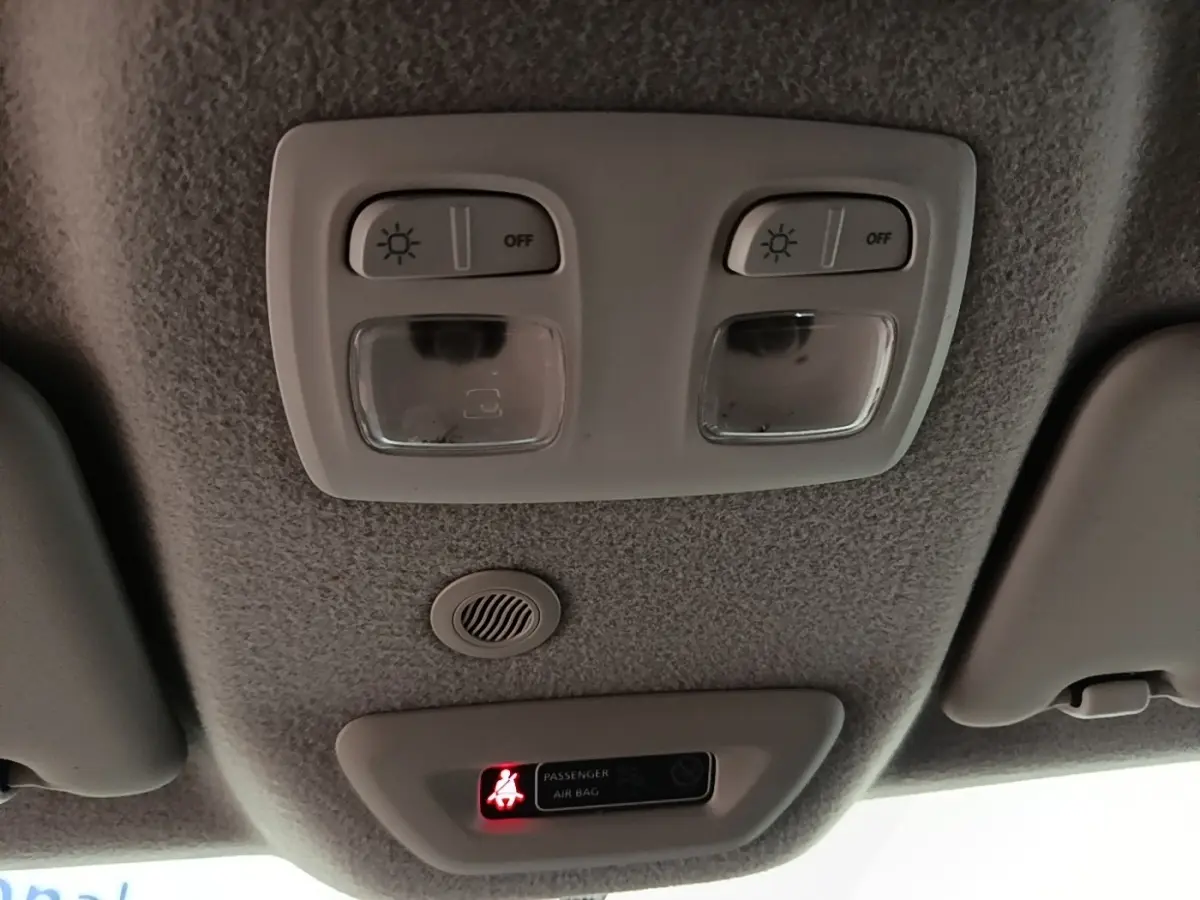 Plafonnier intérieur avec éclairages de lecture et témoin d'airbag passager du Dacia Duster blanc, vue vers le toit.