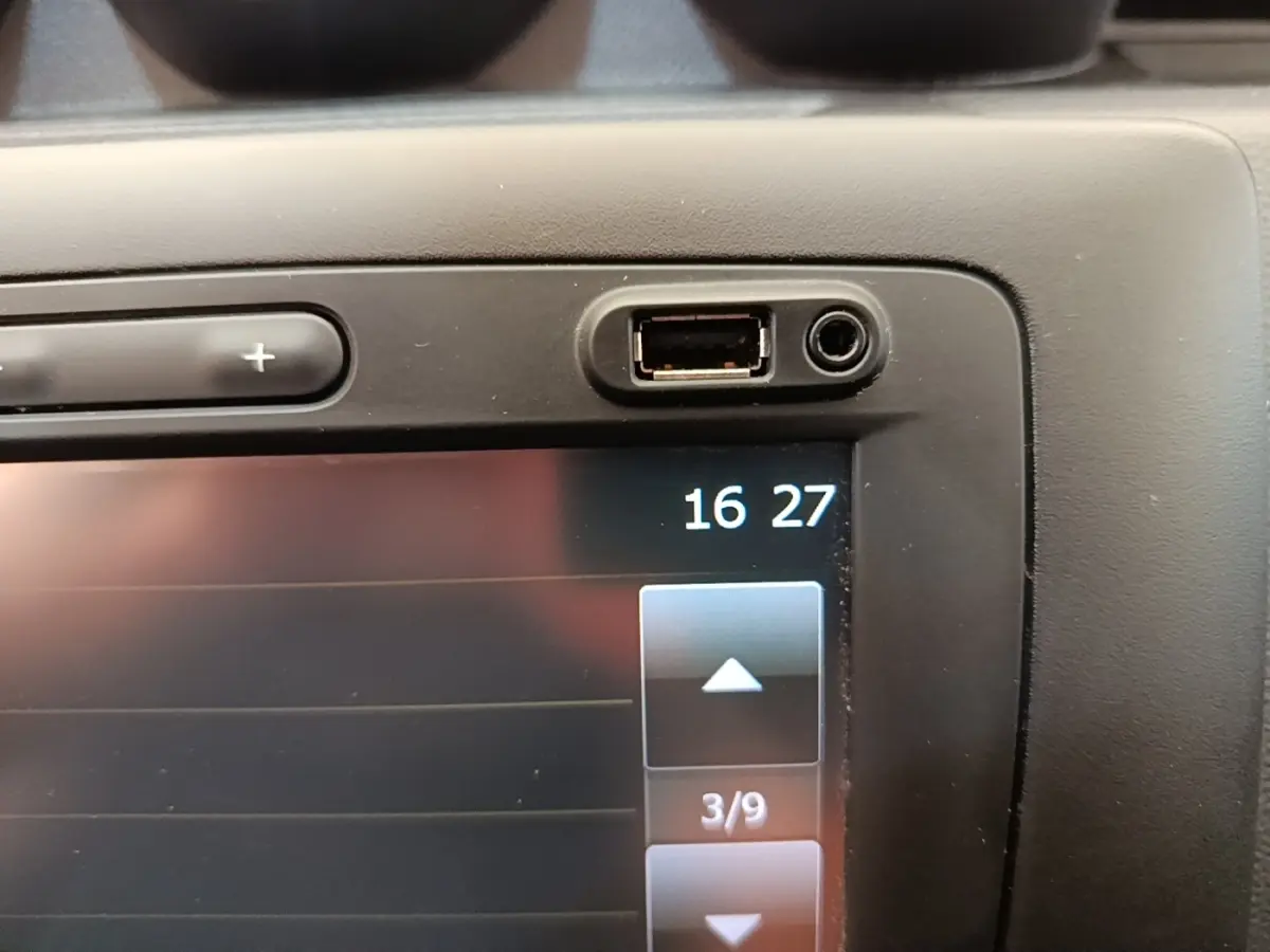 Gros plan sur l’écran tactile central avec port USB et prise jack du Dacia Duster blanc, version Confort Blue dCi 115 4x4.