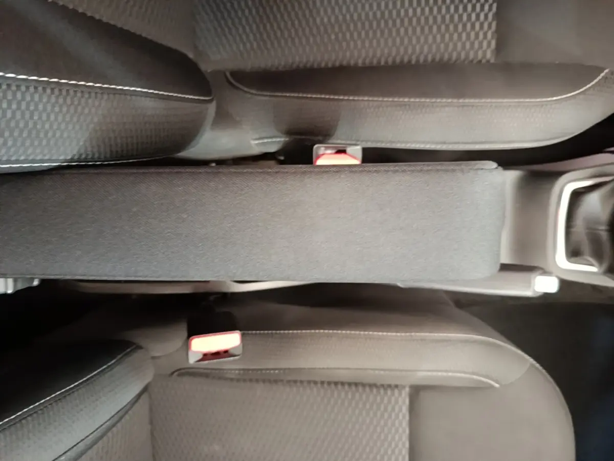 Vue plongeante sur l'accoudoir central et les sièges noirs du Dacia Duster Confort Blue dCi 115 4x4 2021.