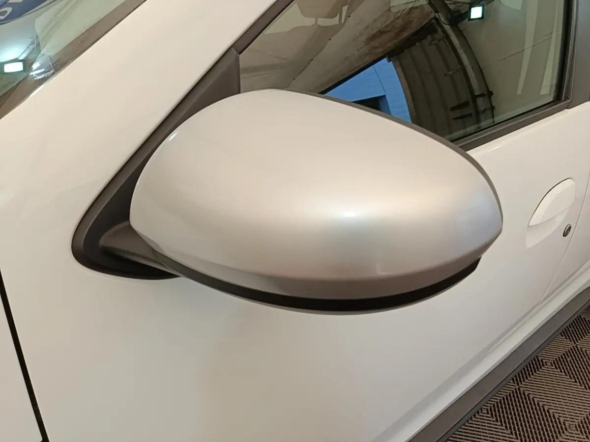 Gros plan sur le rétroviseur côté conducteur blanc du Dacia Duster Confort Blue dCi 115 4x4 blanc, vue latérale droite.