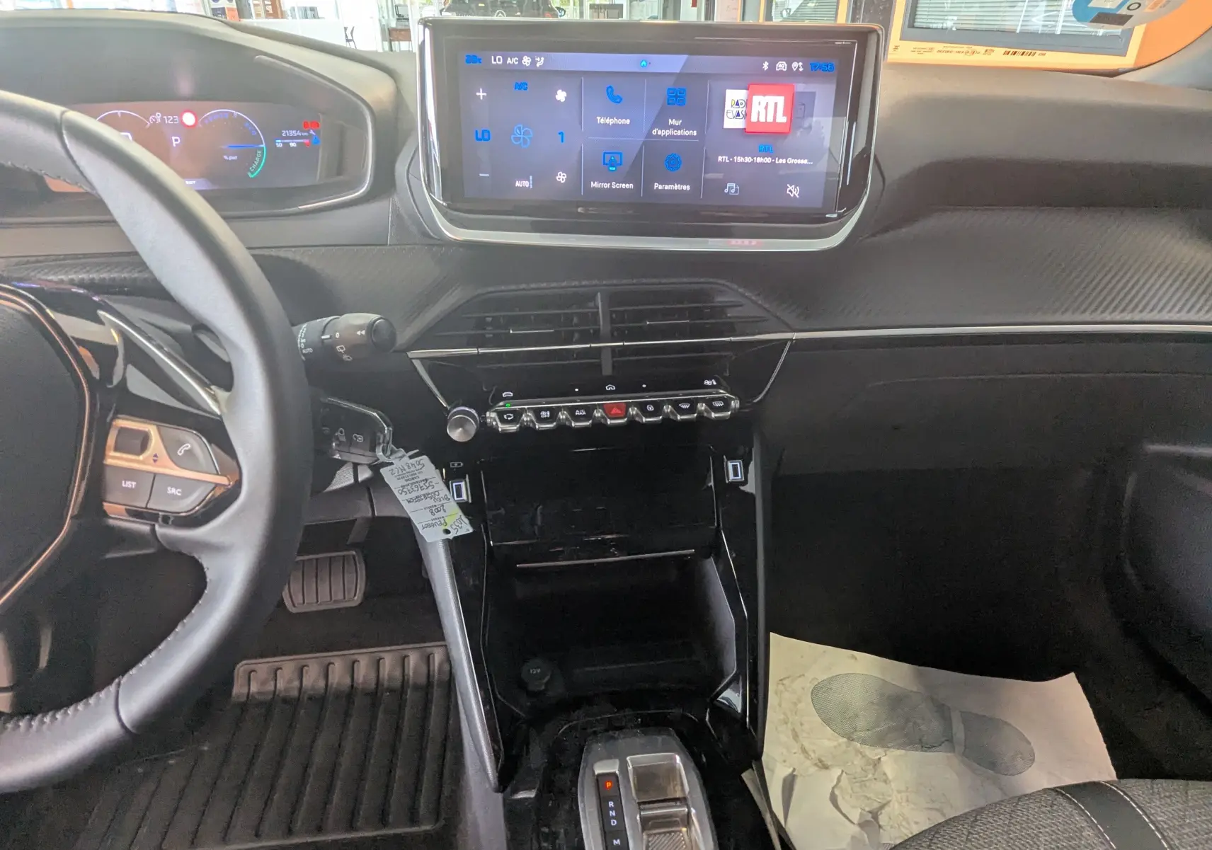 Vue intérieure du tableau de bord du Peugeot 2008 Hybrid 145, avec écran tactile 10 pouces et volant multifonction noir.