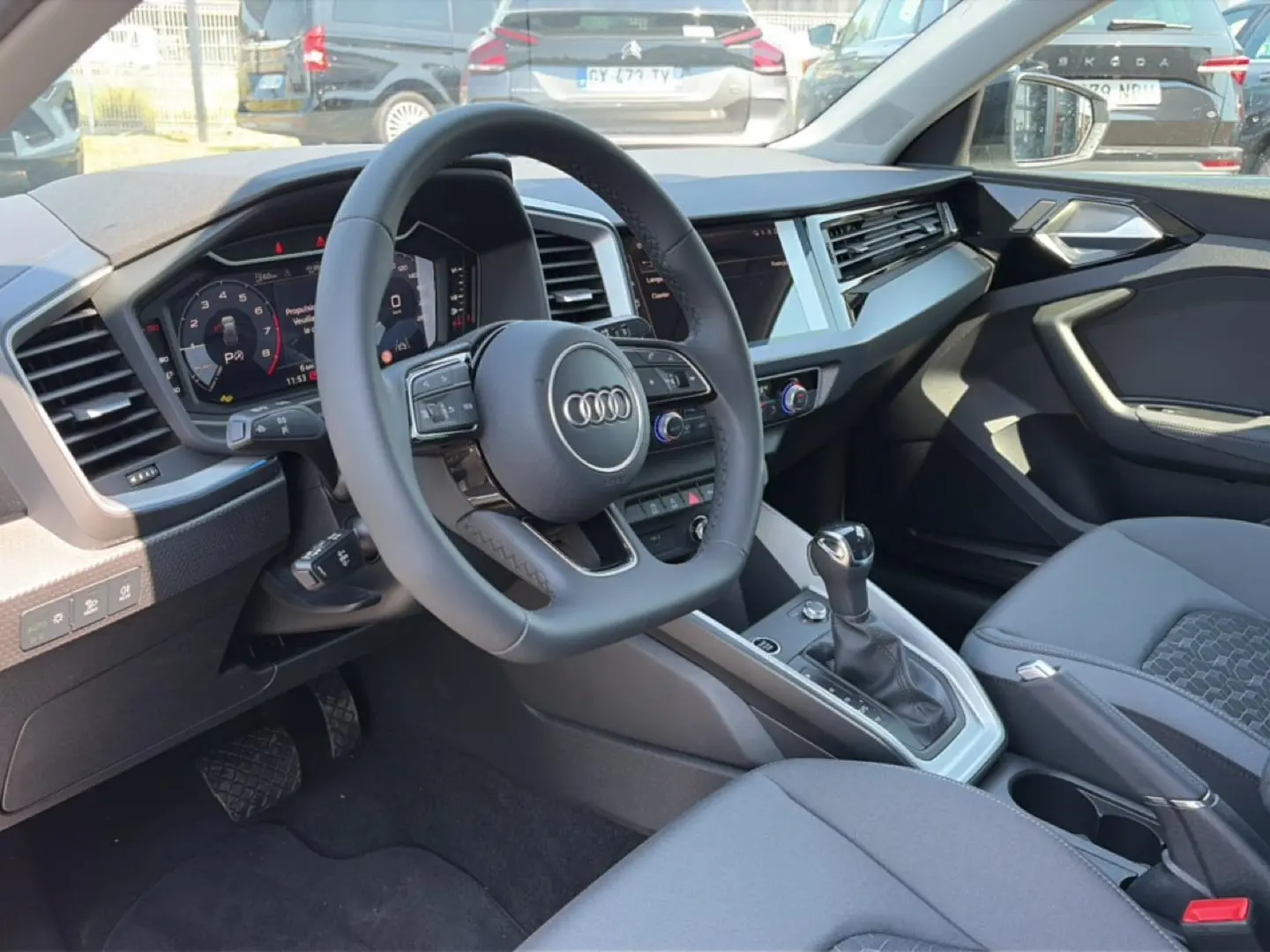 Intérieur Audi A1 Sportback 30 TFSI 2026 vu côté conducteur, tableau de bord moderne et volant cuir multifonction.