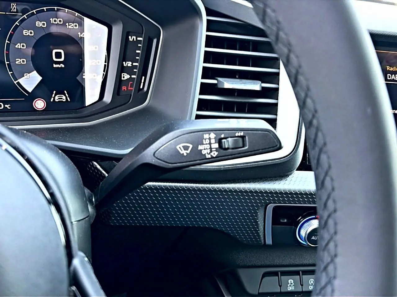 Vue rapprochée du tableau de bord et volant cuir noir de l’Audi A1 Sportback 30 TFSI, affichage digital et commandes intégrées.