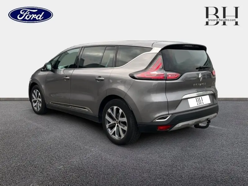 Renault Espace gris Cassiopée vu en 3/4 arrière droit, avec vitres surteintées et jantes alu distinctives.