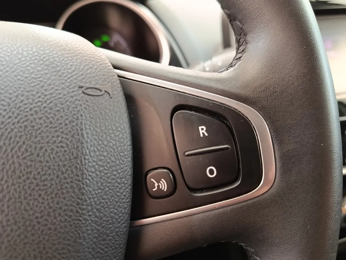Gros plan sur le volant cuir noir de la Renault Clio Business dCi 75, avec commandes multifonctions visibles.