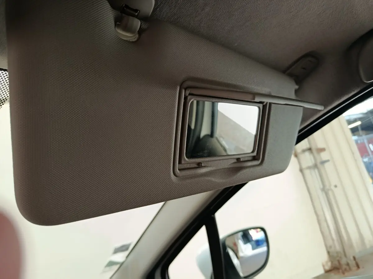 Miroir de courtoisie ouvert sur le pare-soleil côté conducteur d'une Renault Clio Business blanc, vue intérieure.